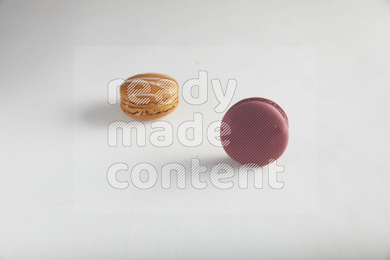 45º Shot of of two assorted Brown Irish Cream, and Red Cherry macarons on white background