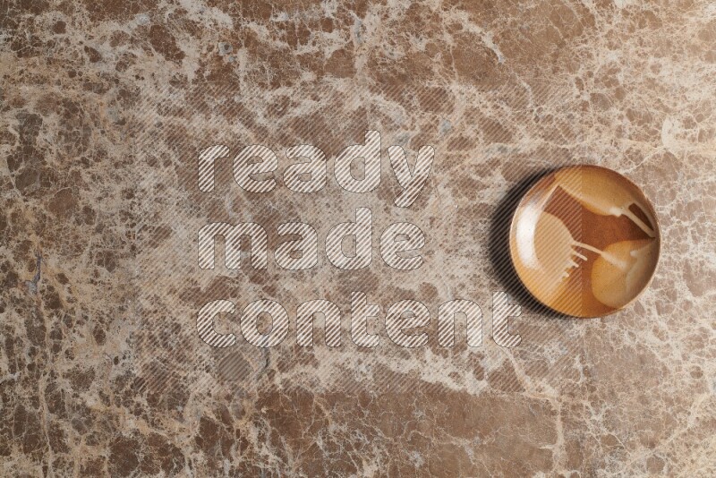 A multicolored pottery plate on beige marble background