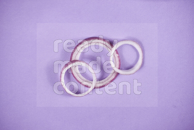 Red onions rings on purple background