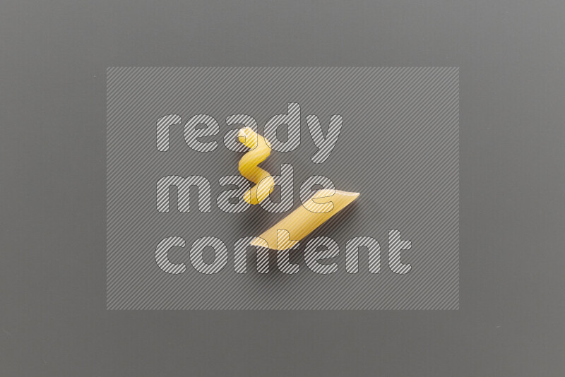 Twist pasta with other types of pasta on grey background