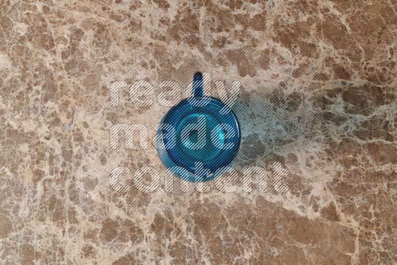 A colored glass jug on beige marble background