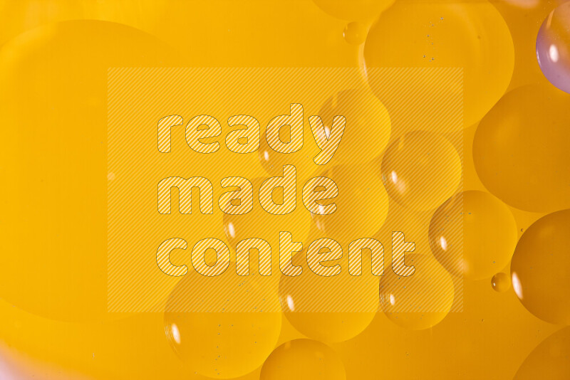 Close-ups of abstract oil bubbles on water surface in shades of orange