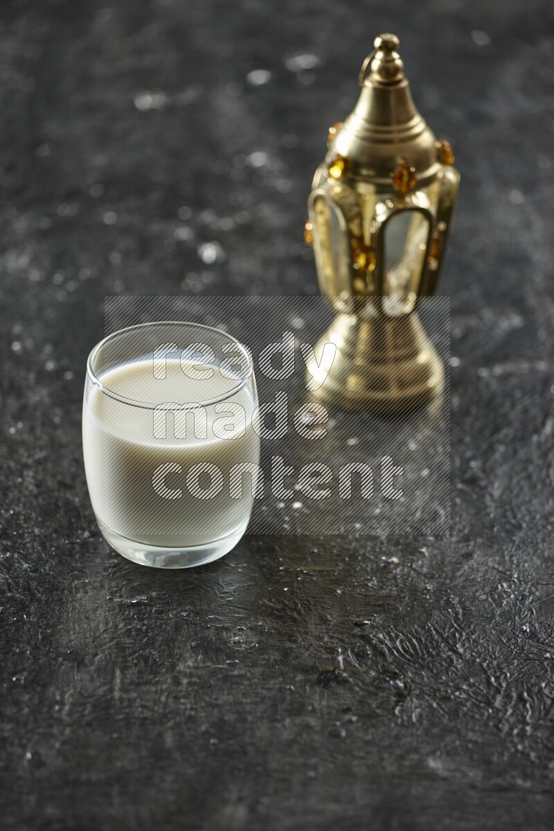 فانوس ذهبي مع مشروبات مختلفة وتمر ومكسرات وسبحة صلاة وقرآن على خلفية سوداء