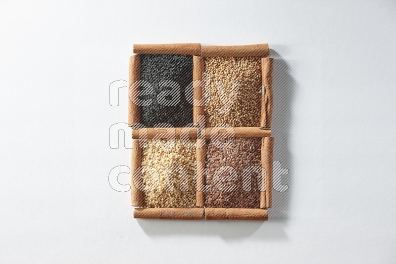 4 squares of cinnamon sticks full of black seeds, mustard seeds, flaxseeds and sesame on white flooring