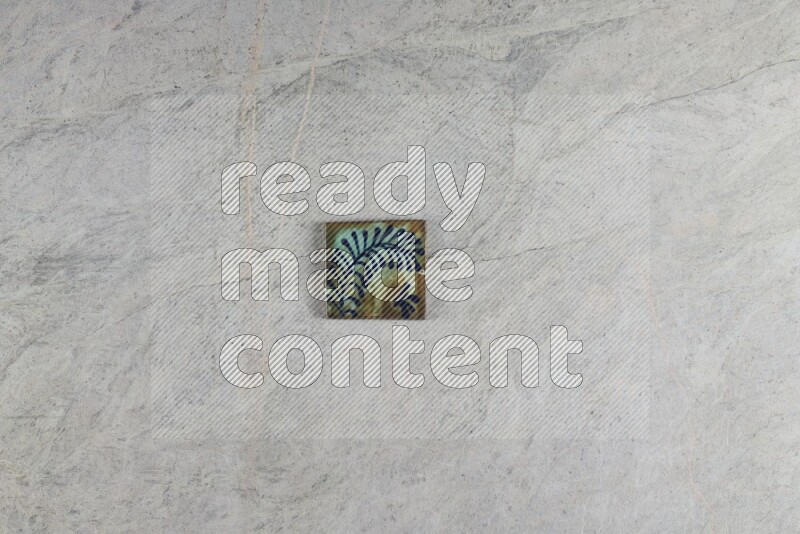 A decorative pottery coaster on grey marble background