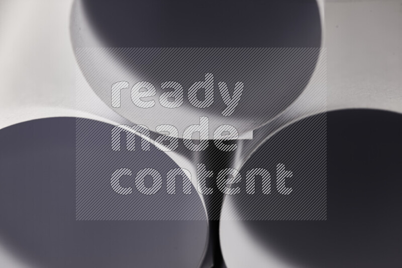 The image shows an abstract paper art with circular shapes in varying shades of grey