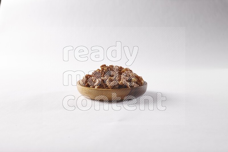 Walnuts in a wooden bowl on white background