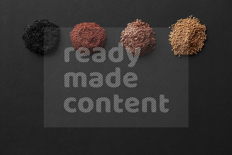 Black seeds, mustard seeds, garden cress and flax on a Black background