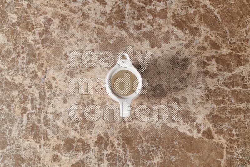 إبريق حليب خزفي على خلفية من الرخام البيج