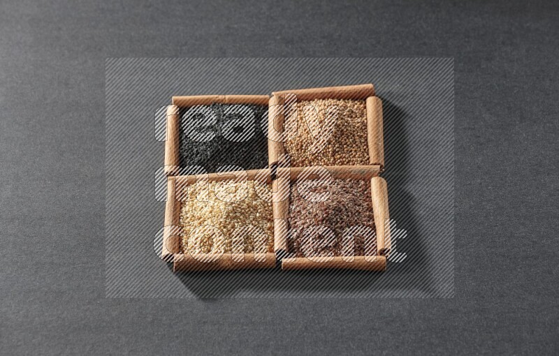 4 squares of cinnamon sticks full of black seeds, sesame, flaxseeds and mustard seeds on black flooring