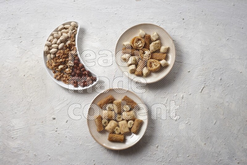 Oriental sweets in pottery plates with nuts in a light setup