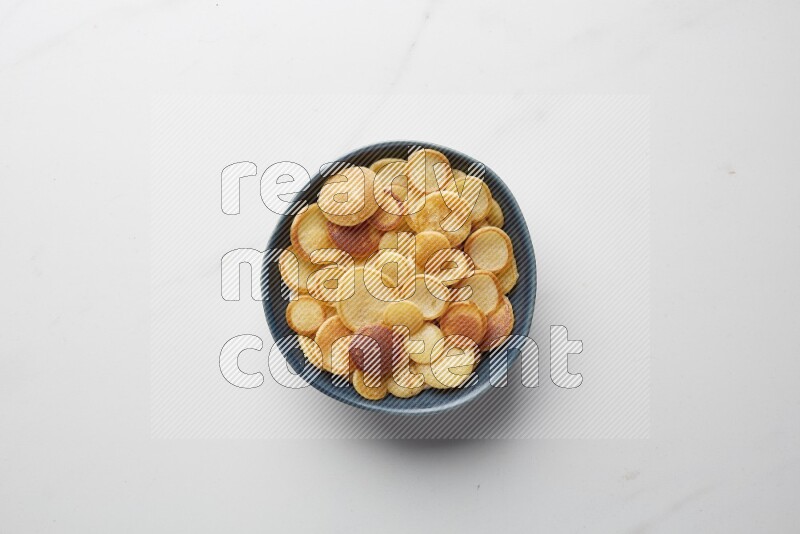 Top-view shot of plain cereal pancakes in a round bowl on white background