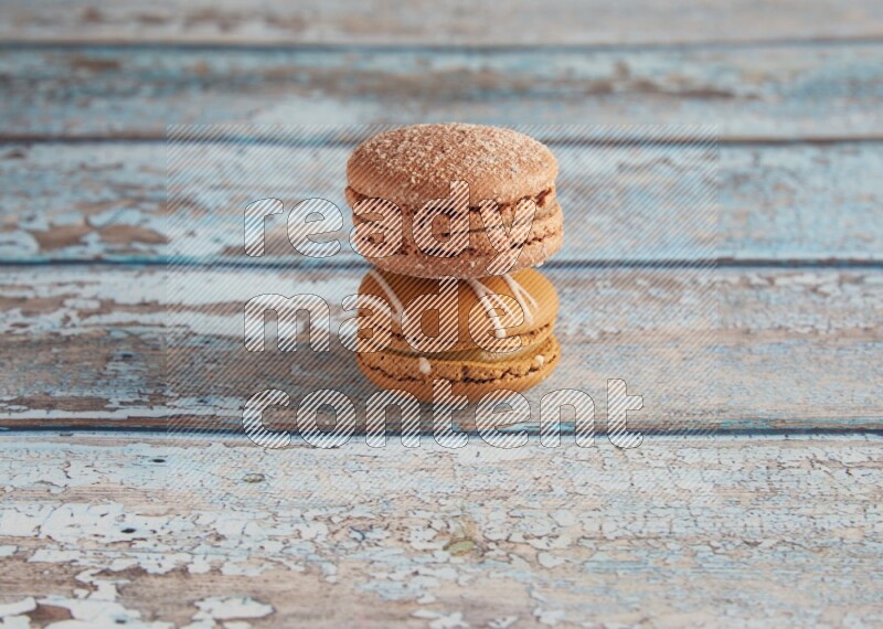 45º Shot of of two assorted Brown Irish Cream, and Brown Hazelnuts macarons  on light blue background