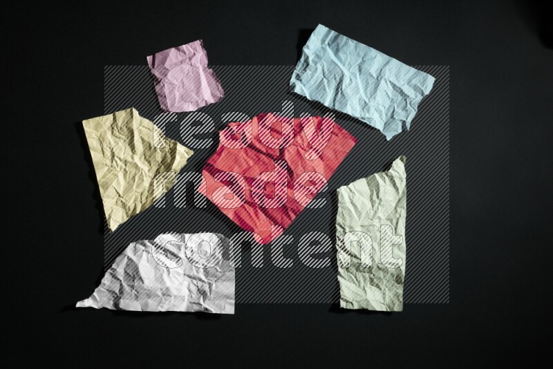 Crumpled multicolored paper on black background
