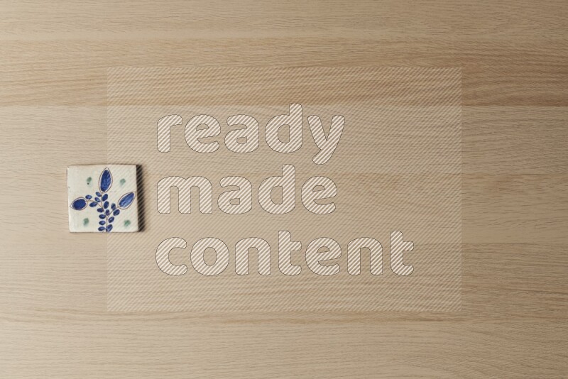 A decorative pottery coaster on light wooden background