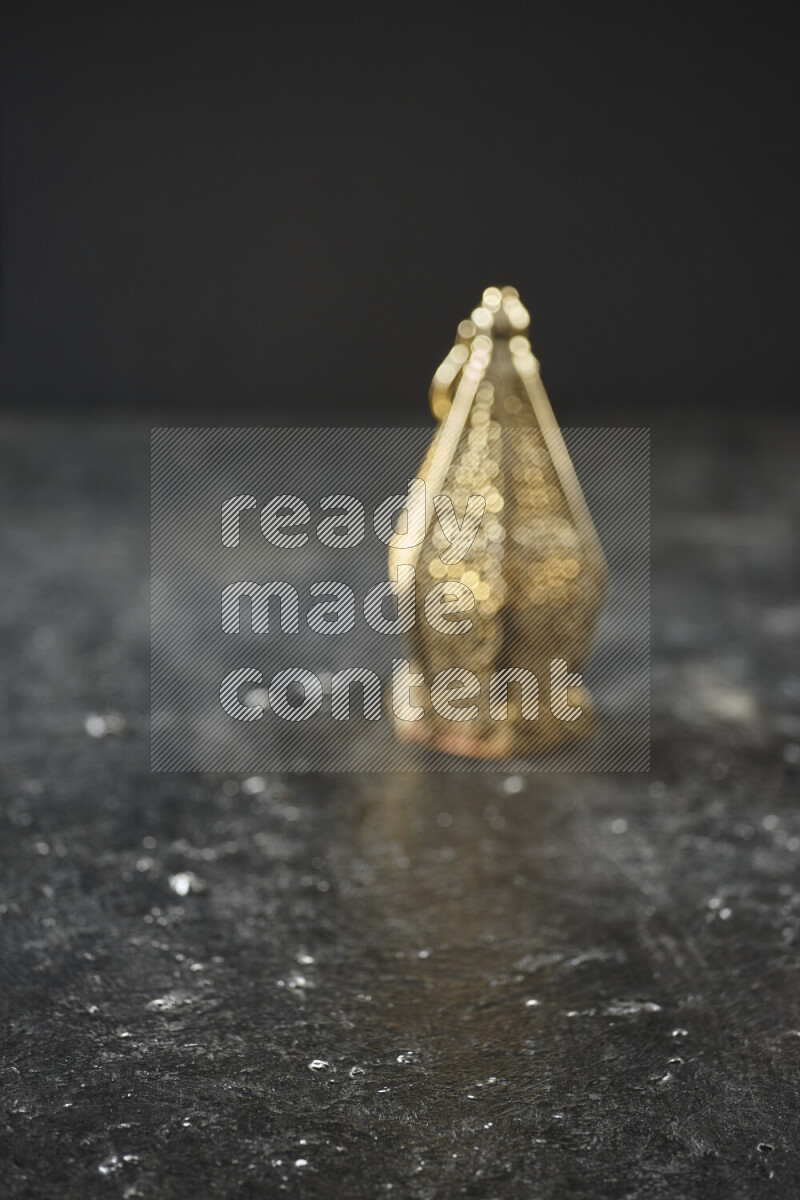 A lantern placed on a textured black background