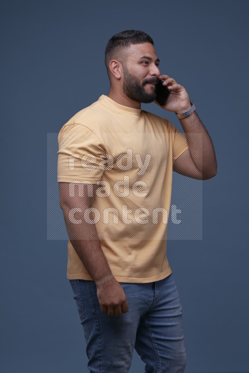 A man Calling on Blue Background wearing Orange T-shirt