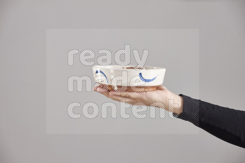 A woman in black abaya holding different pottery essentials in different positions