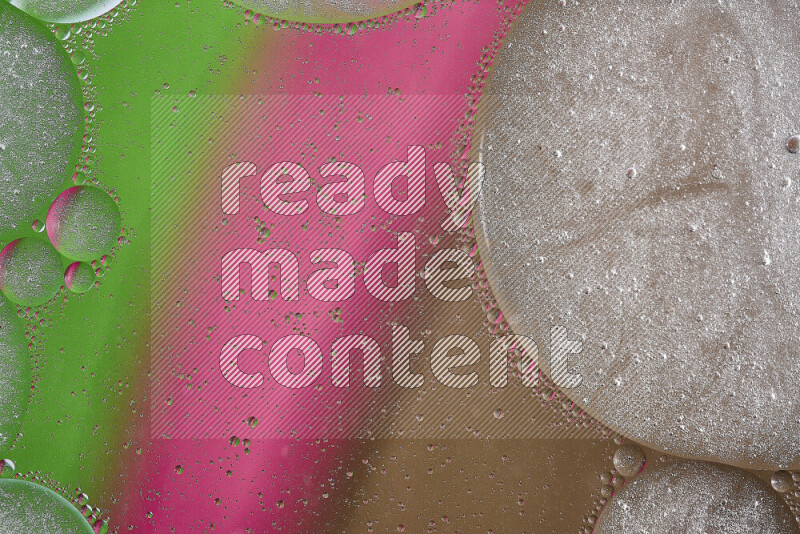 لقطات مقربة لفقاعات من الزيت على سطح الماء باللون البني والأخضر والوردي