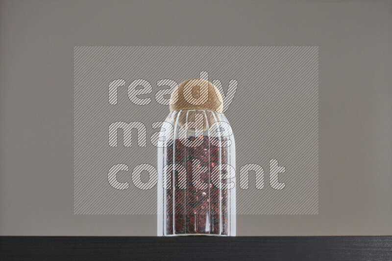 Sequins in a glass jar on black background