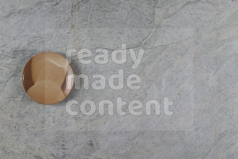A multicolored pottery plate on grey marble background