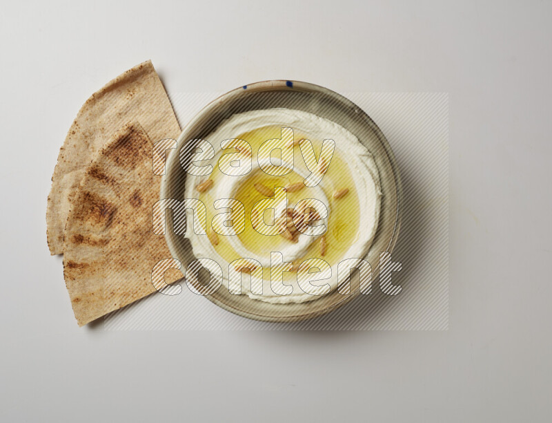 Lebnah garnished with pine nuts in a grey pottery plate on a white background