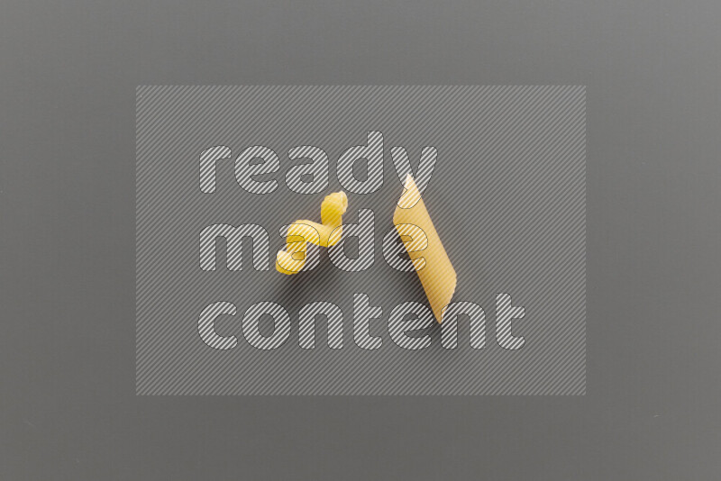 Twist pasta with other types of pasta on grey background