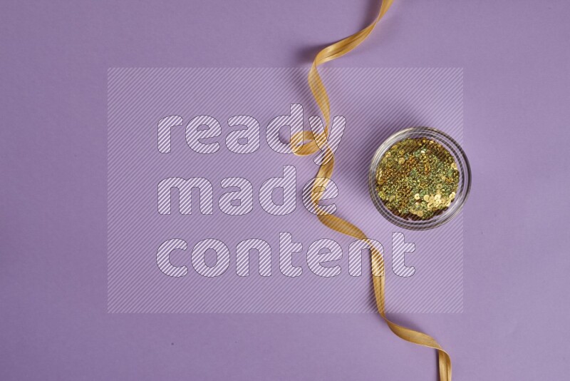 A yellow and purple collection of sewing and tailoring tools arranged on a purple background