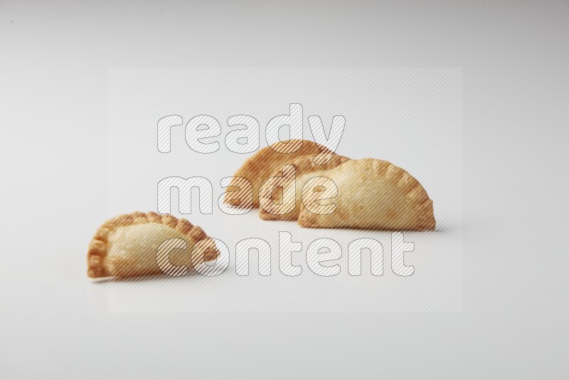 Four fried sambosas on a white background