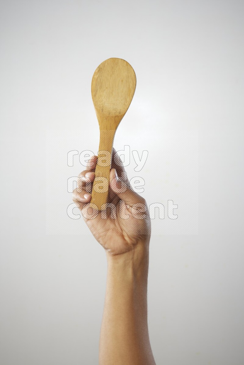 Male Hand Holding Wooden spoon on white background