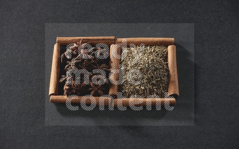 2 squares of cinnamon sticks full of cumin and star anise on black flooring