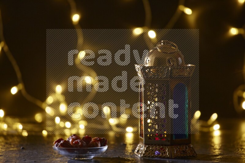 A traditional ramadan lantern surrounded by glowing fairy lights in a dark setup