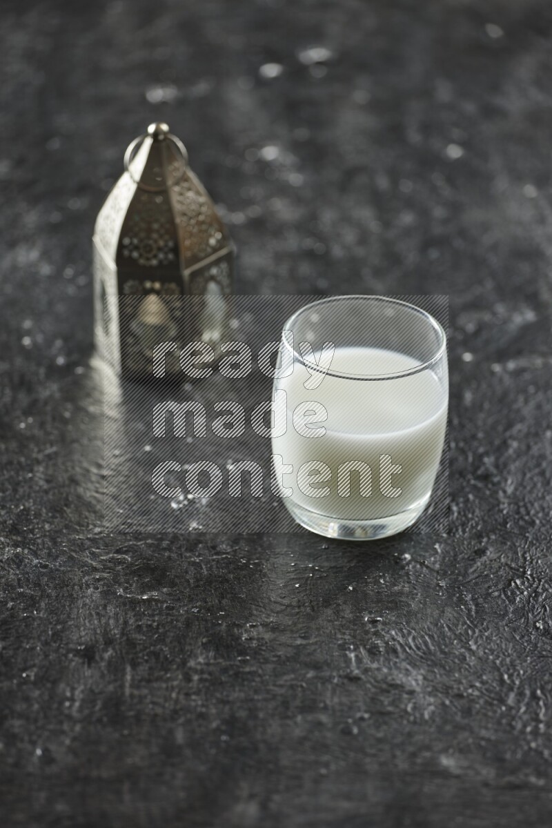 فانوس فضي مع مشروبات مختلفة وتمر ومكسرات وسبحة صلاة وقرآن على خلفية سوداء