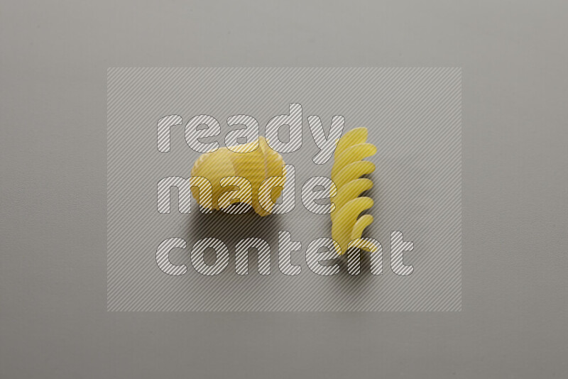 Pipe pasta with other types of pasta on grey background