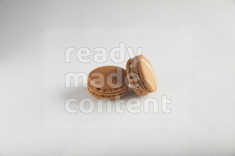45º Shot of of two assorted Brown Irish Cream, and Brown Maple Taffy macarons  on white background