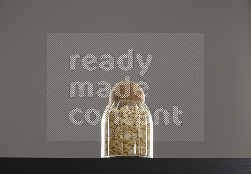 Crushed beans in a glass jar on black background
