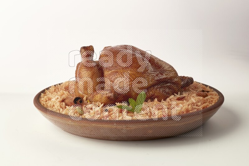 red basmati Rice with whole roasted chicken on a pottery plate direct on white background