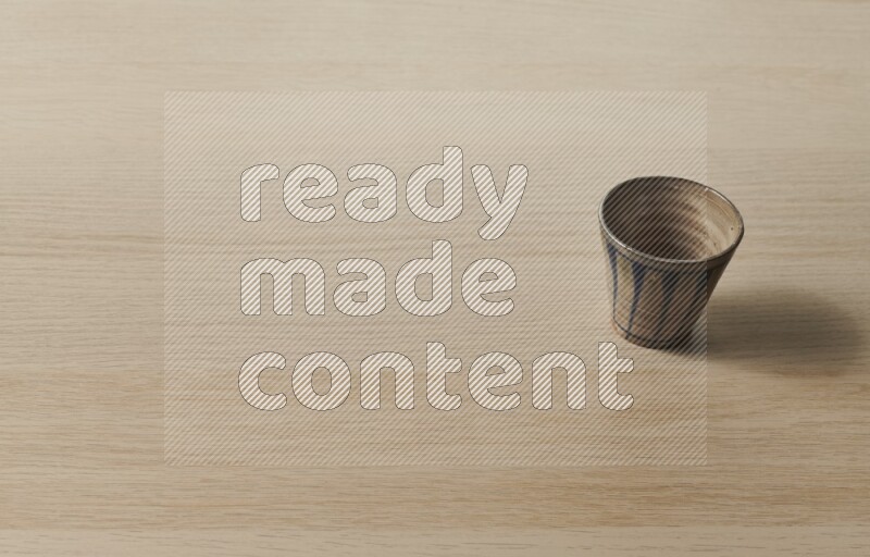 A pottery cup on light wooden background