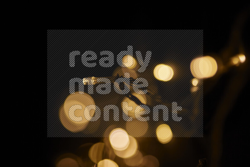 Light bulbs glowing against backdrop of golden bokeh