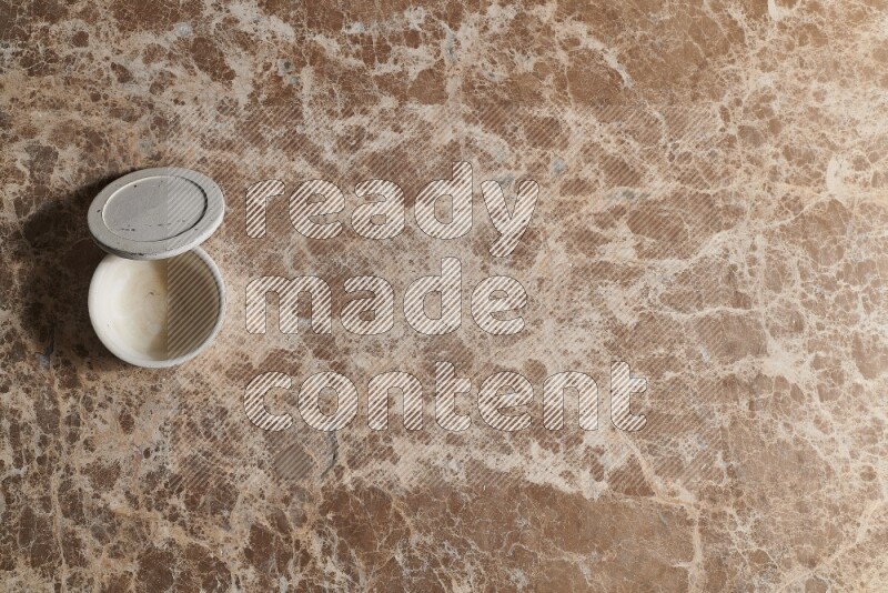 A pottery cup on beige marble background