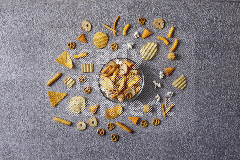 Assorted snacks in pottery bowls on grey background
