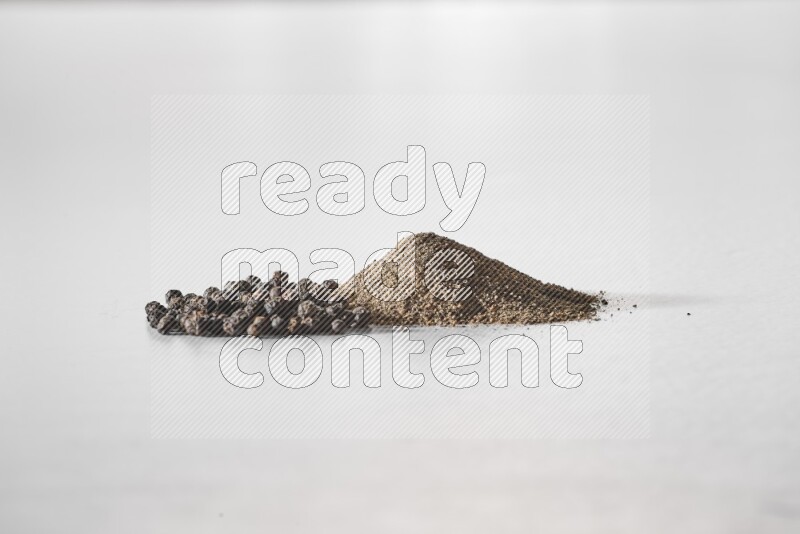 Black pepper powder and beads on a white background