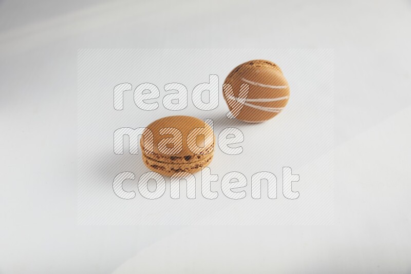 45º Shot of of two assorted Brown Irish Cream, and Brown Maple Taffy macarons  on white background
