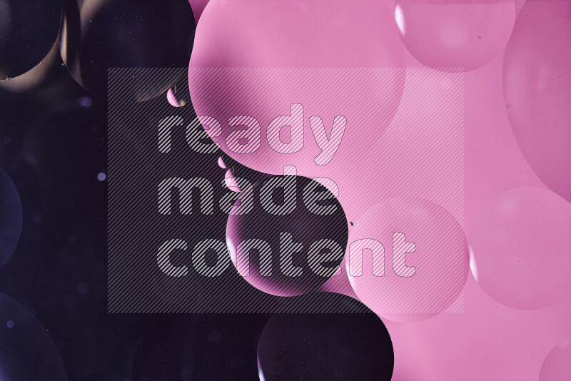 Close-ups of abstract oil bubbles on water surface in shades of black and pink