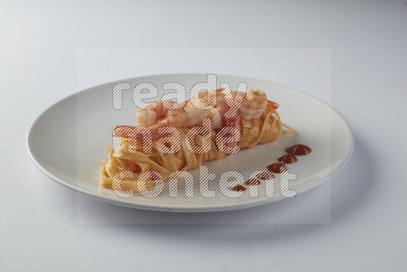 Fettuccini red sauce pasta with shrimp in a white plate on a white background