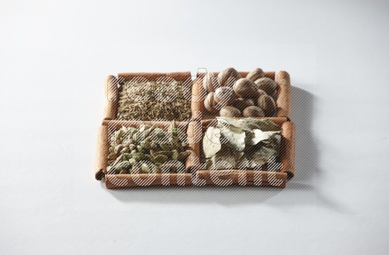 4 squares of cinnamon sticks full of nutmegs, bay laurel leaves, cardamom and cumin on white flooring