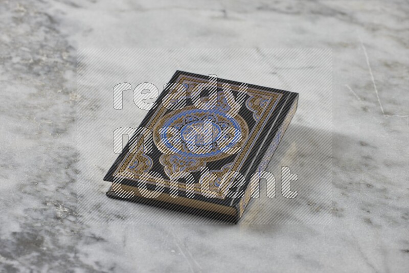 Quran with a prayer beads on grey marble background