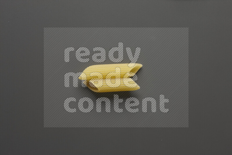 Penne pasta on grey background