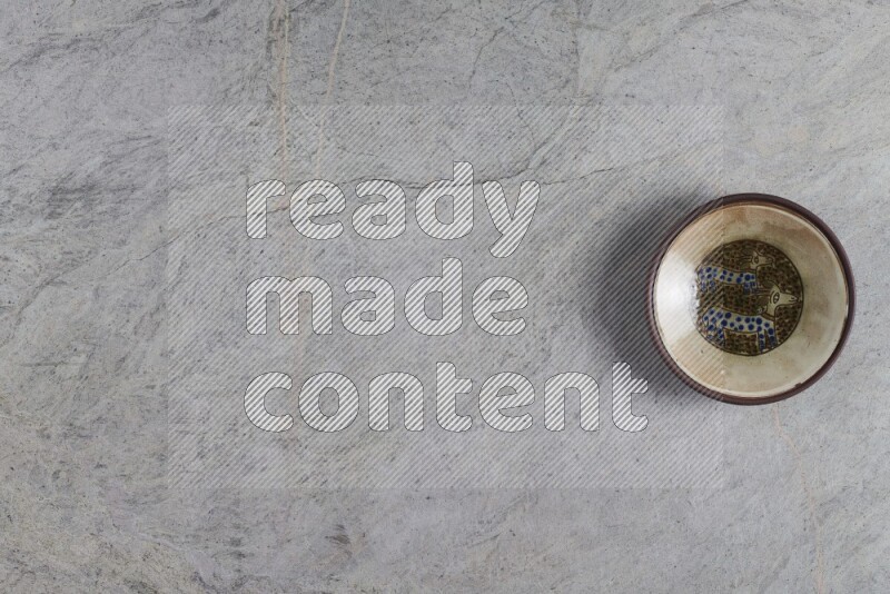 A decorative pottery plate on grey marble background