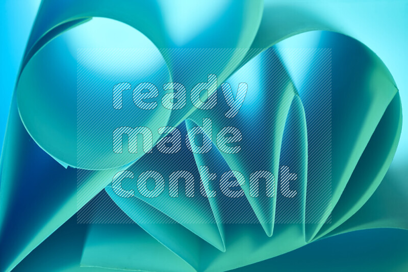 An artistic display of paper folds creating a harmonious blend of geometric shapes, highlighted by soft lighting in green and blue tones